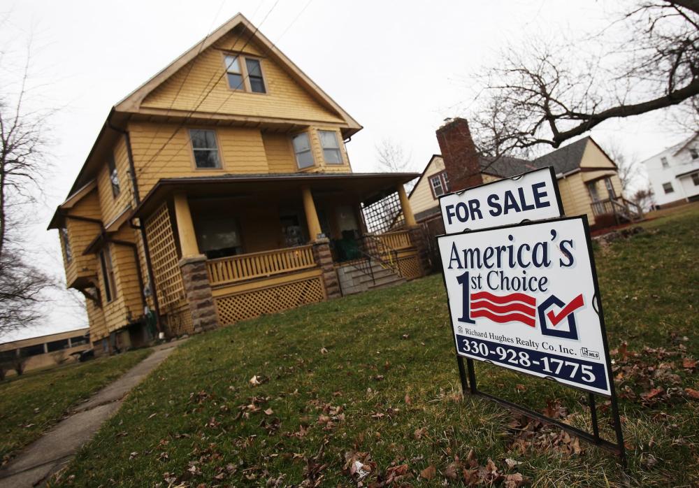 A for sale sign is seen outside a house in Maple Heights a suburb of Cleveland,Ohio March 1, 2012.