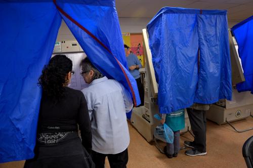 An election worker helps a voter use the voting machine during the U.S. presidential election in Philadelphia, Pennsylvania, U.S. November 8, 2016.