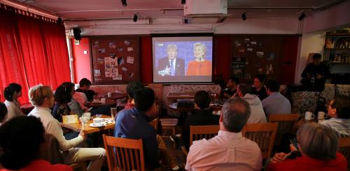 People watch a direct broadcast of the first U.S. presidential debate between Republican U.S. presidential nominee Donald Trump and Democratic U.S. presidential nominee Hillary Clinton at a cafe in Beijing, China, September 27, 2016. REUTERS/Damir Sagolj - RTSPKXI