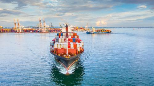 A shipping boat pulling out of a port.