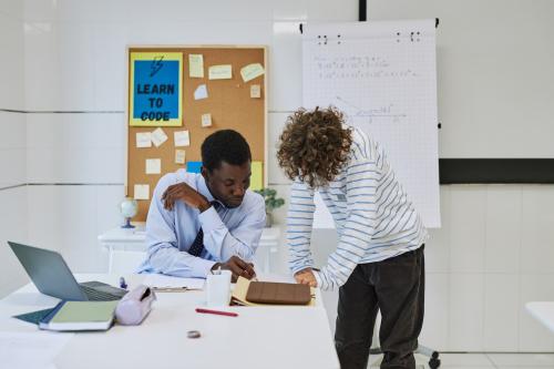 Teacher assists student with assignment. Source: Shutterstock